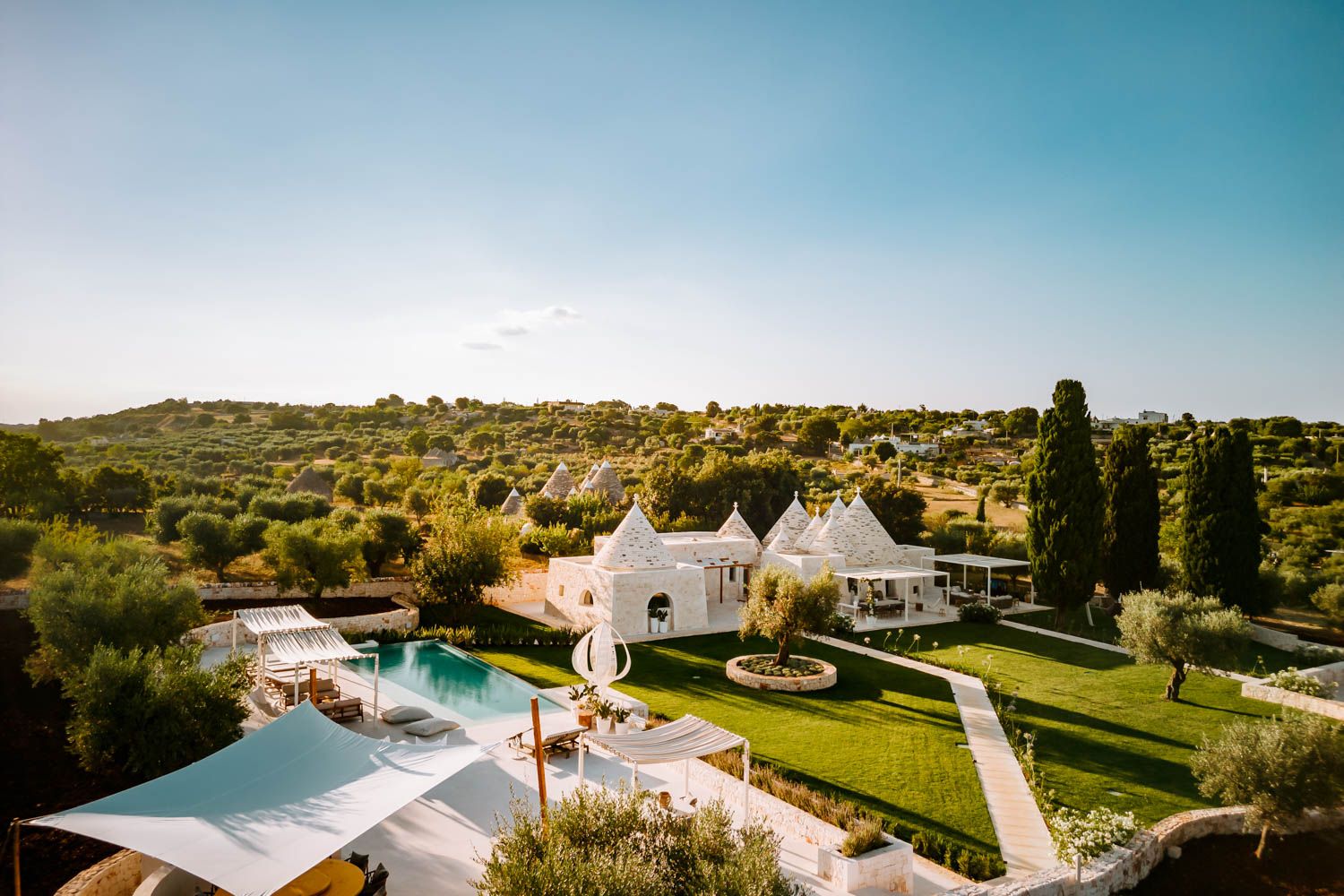 Trullo Acanto aerial view showing conical roofs and pool terrace, Cisternino, Puglia, Italy