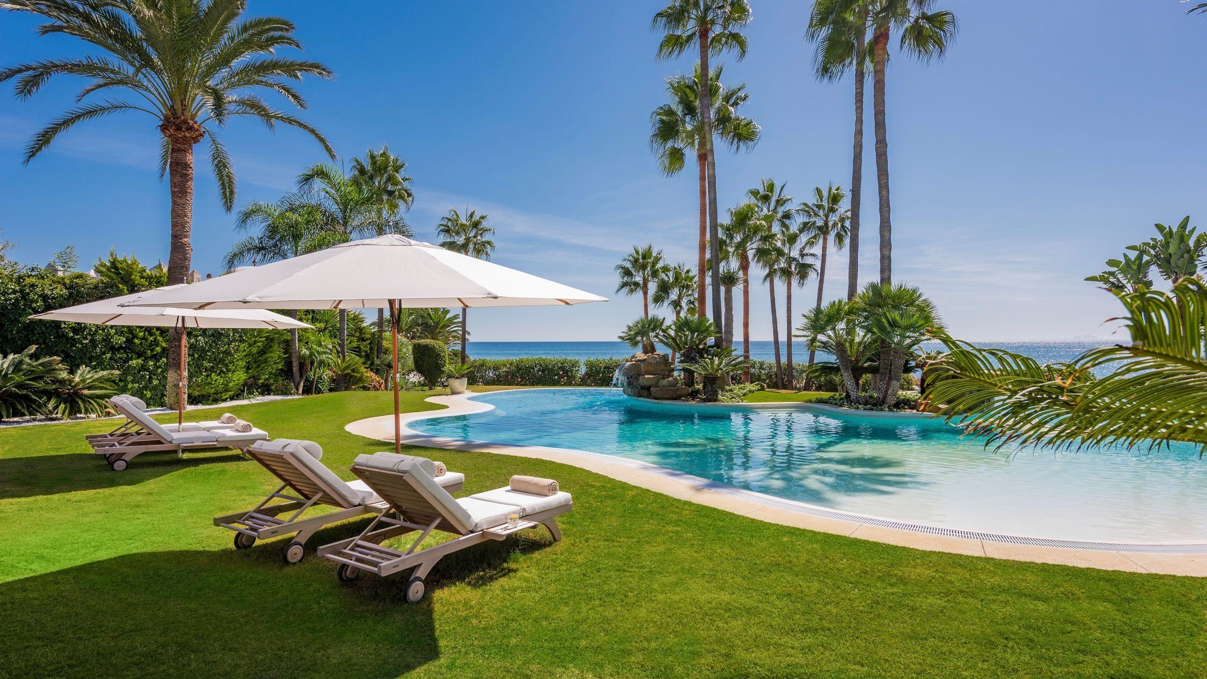 Villa Tesoro lagoon-style pool with tropical palms and beachfront access, Marbella, Spain