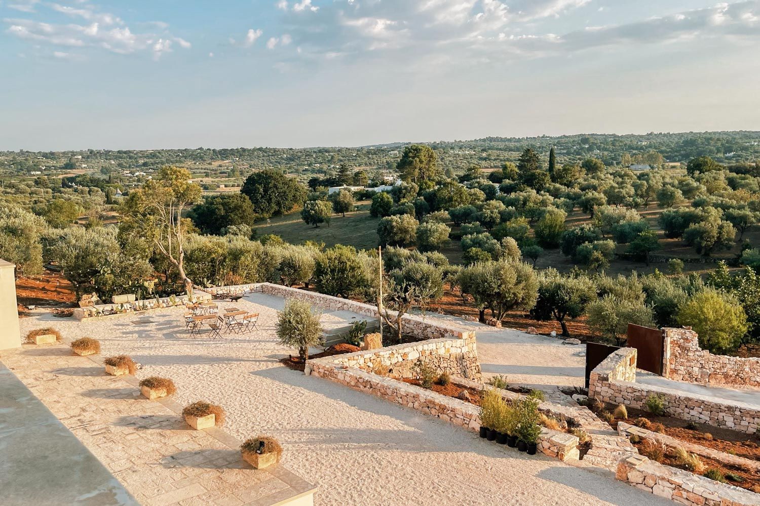 Villa Lucantu outdoor terrace with dry-stone walls and olive grove views, Cisternino, Puglia, Italy