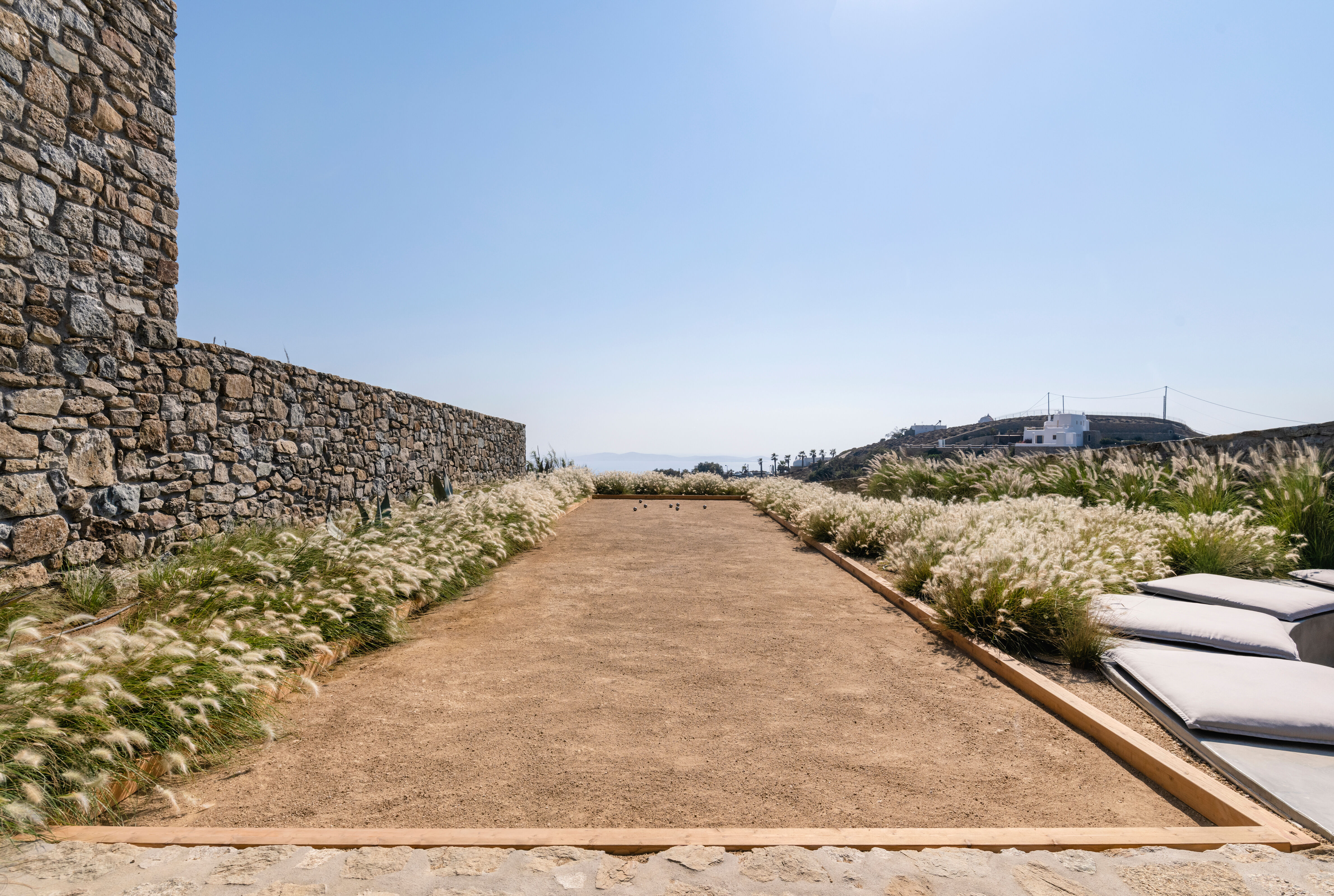 Villa Iliada landscaped pathway through ornamental grasses and stone walls, Mykonos, Greece