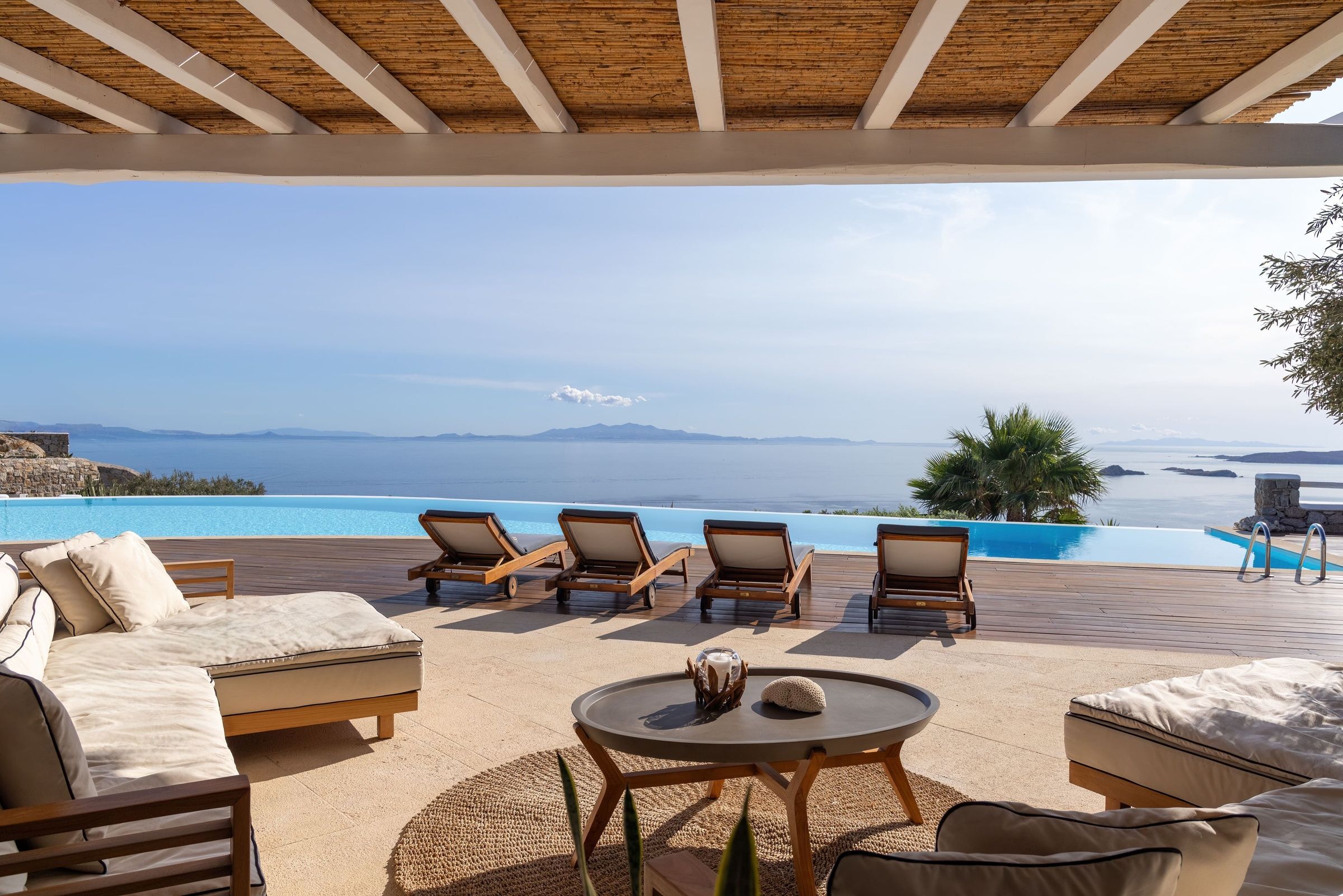 Villa Infinite Breeze infinity pool deck with wooden loungers, Mykonos, Cyclades Islands, Greece